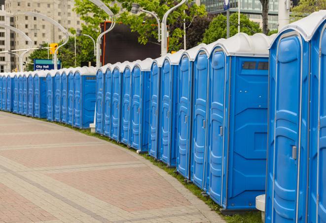 a row of portable restrooms set up for a large athletic event, allowing participants and spectators to easily take care of their needs in Granby, CT